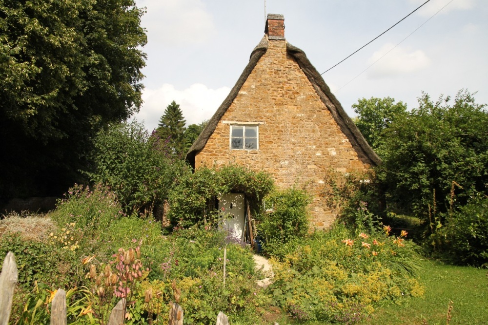 Photograph of A traditional old cottage with its pretty cottage garden at Alkerton