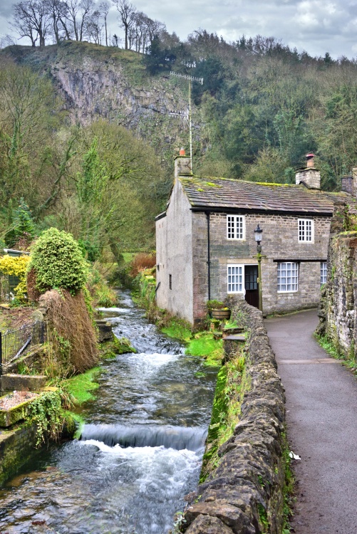 Peakshole Water Flowing Through Castleton with the Cliffs Above